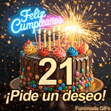 El número 21 brilla sobre un pastel decorado con dulces. Lluvia de estrellas y una fuente de chispas iluminan las letras de Feliz Cumpleaños.