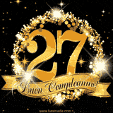 Il numero 27 è circondato da un anello dorato brillante, accompagnato da un nastro elegante con la scritta 'Buon Compleanno!' su uno sfondo scuro.