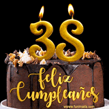 GIF de un pastel de chocolate con decoración de crema, velas doradas con el número 38 encendido, y un fondo negro elegante y cálido.