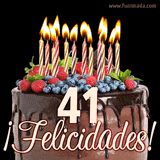 Animación de un pastel de chocolate decorado con frutas, velas encendidas y el número 41, acompañado de la palabra '¡Felicidades!' en elegante tipografía.