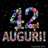 Il numero 42 e l'espressione Auguri disegnati da gioielli brillanti multicolori, circondati da piccole scintille su uno sfondo scuro.