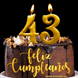 GIF de un pastel de chocolate con decoración de crema, velas doradas con el número 43 encendido, y un fondo negro elegante y cálido.