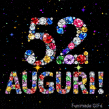 Immagine che mostra il numero 52 e il testo Auguri composti da cristalli luminosi di vari colori su una tela nera piena di stelle animate.