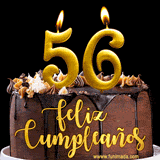GIF de un pastel de chocolate con decoración de crema, velas doradas con el número 56 encendido, y un fondo negro elegante y cálido.