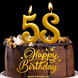58th birthday GIF featuring a chocolate birthday cake displaying 'Happy Birthday' lettering in gold, and two lit gold candles shaped as '58' lighting up the top.