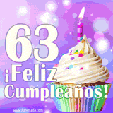 Animación de un cupcake con cobertura blanca, confites de colores, una vela encendida y el número 63 en grande sobre un fondo púrpura con luces brillantes.
