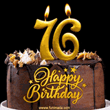 76th birthday GIF featuring a chocolate birthday cake displaying 'Happy Birthday' lettering in gold, and two lit gold candles shaped as '76' lighting up the top.