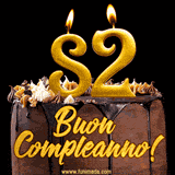 GIF animato con una torta al cioccolato decorata con crema, dettagli dorati e due candele accese che formano il numero 82. Messaggio 'Buon Compleanno' in scritta elegante.