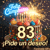 Torta festiva con luces de neón y el número 83. Una bengala encendida desprende chispas brillantes mientras caen estrellas sobre el glaseado oscuro.