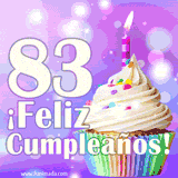Animación de un cupcake con cobertura blanca, confites de colores, una vela encendida y el número 83 en grande sobre un fondo púrpura con luces brillantes.
