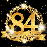 Il numero 84 è circondato da un anello dorato brillante, accompagnato da un nastro elegante con la scritta 'Buon Compleanno!' su uno sfondo scuro.