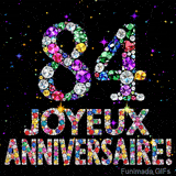 Le chiffre 84 et les mots Joyeux Anniversaire en cristaux colorés brillants, se détachant sur un fond noir rempli de petites étoiles animées.