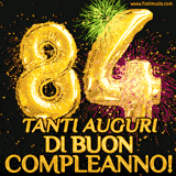 Palloncini dorati a forma del numero 84, accompagnati da scintille e fuochi d'artificio su sfondo nero, con il messaggio 'Tanti auguri di Buon Compleanno!'.