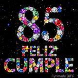 Imagen donde el número 85 y las palabras FELIZ CUMPLE están armados mediante cristales muy coloridos sobre fondo negro con pequeñas luces.