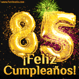 GIF animado con globos dorados en forma del número 85, acompañado de fuegos artificiales de colores y la frase '¡Feliz cumpleaños!' en letras vibrantes.