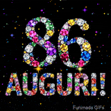 Il numero 86 e la scritta Auguri creati con gioielli brillanti di diverse tonalità su un fondo nero animato da piccole scintille di luce.