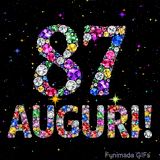 Il numero 87 e l'espressione Auguri disegnati da pietre preziose scintillanti su uno sfondo nero con piccole stelle luminose.