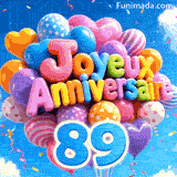 Des mots en ballons colorés lisant Joyeux Anniversaire flottent dans la brise, accompagnés du grand chiffre bleu 89 attaché aux rubans.