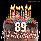 Animación de un pastel de chocolate decorado con frutas, velas encendidas y el número 89, acompañado de la palabra '¡Felicidades!' en elegante tipografía.