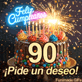 Un espectacular bizcocho de chocolate resalta con la cifra 90. Chispas saltan de una gran bengala, acompañadas del mensaje de celebración ¡Pide un deseo!.