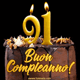 GIF animato con una torta al cioccolato decorata con crema, dettagli dorati e due candele accese che formano il numero 91. Messaggio 'Buon Compleanno' in scritta elegante.