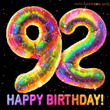 Shiny number 92 birthday celebration balloons with an iridescent glow and glitter on a black background with twinkling stars.