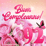 Immagine animata per i 92 anni: GIF di rose rosa, farfalla in volo e luci celebrative su sfondo sfumato arancio e rosa.
