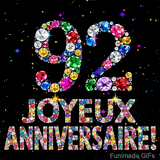 Le chiffre 92 et les mots Joyeux Anniversaire en cristaux colorés brillants, se détachant sur un fond noir rempli de petites étoiles animées.