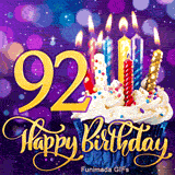 Gold number 92 and Happy Birthday lettering near a blue-wrapped cupcake topped with burning candles, against a glowing purple bokeh backdrop.