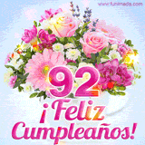 GIF de un colorido ramo de flores rosas, lilas y blancas, con el número 92 destacado en rosa y el mensaje '¡Feliz cumpleaños!' en un estilo encantador.