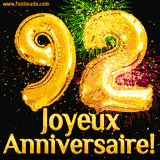GIF animé pour un 92e anniversaire avec des ballons dorés en forme de 92, des feux d'artifice colorés et le texte 'Joyeux Anniversaire!' sur un fond noir festif.