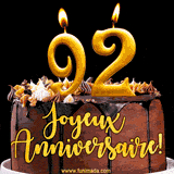 GIF animé pour un 92e anniversaire avec une élégante gâteau au chocolat, des bougies dorées formant le chiffre 92 et le texte 'Joyeux Anniversaire!' en écriture dorée.