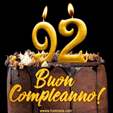 GIF animato con una torta al cioccolato decorata con crema, dettagli dorati e due candele accese che formano il numero 92. Messaggio 'Buon Compleanno' in scritta elegante.