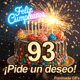 Luces de bengala resplandecen sobre un rico postre con el número 93. Confeti con forma de estrella acompaña al letrero neón de Feliz Cumpleaños.