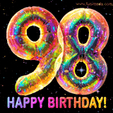 Shiny number 98 birthday celebration balloons with an iridescent glow and glitter on a black background with twinkling stars.