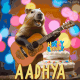 Animated birthday GIF showing a capybara playing guitar and singing beside a birthday cake with the name Aadhya in large letters and colorful bokeh lights in the background.