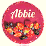 Beautifully decorated red velvet berry birthday cake with vibrant fruits and a glowing 'Abbie' name, adding a touch of sweetness and sparkle.