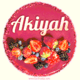 Beautifully decorated red velvet berry birthday cake with vibrant fruits and a glowing 'Akiyah' name, adding a touch of sweetness and sparkle.