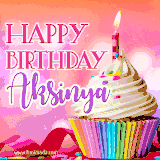 A vibrant birthday GIF featuring a rainbow-colored cupcake topped with white frosting, sprinkles, and a lit candle. The text reads 'Happy Birthday Aksinya' in bold pink and violet letters with white outline.