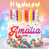 A cheerful white birthday cake with multicolor sprinkles, lit candles, and 'Amalia' written in vibrant letters, in an animated GIF.