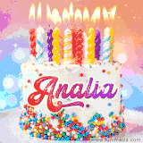 A cheerful white birthday cake with multicolor sprinkles, lit candles, and 'Analia' written in vibrant letters, in an animated GIF.
