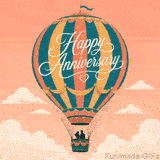 A large striped hot air balloon in teal, orange, and yellow carrying a couple in its basket floats among soft white clouds under a warm peach sky.