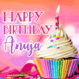 A vibrant birthday GIF featuring a rainbow-colored cupcake topped with white frosting, sprinkles, and a lit candle. The text reads 'Happy Birthday Anuja' in bold pink and violet letters with white outline.