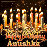 A glowing personalized birthday GIF with name Anushka featuring lit candles with intricate designs, warm lighting, and the text 'Happy Birthday' in an elegant font.