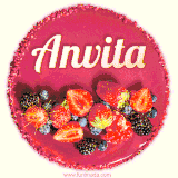 Beautifully decorated red velvet berry birthday cake with vibrant fruits and a glowing 'Anvita' name, adding a touch of sweetness and sparkle.