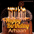 A rich chocolate cake topped with glowing birthday candles and surrounded by bright fireworks. The animated GIF displays the message 'Happy Birthday Arhaan' in golden text.
