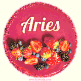 Beautifully decorated red velvet berry birthday cake with vibrant fruits and a glowing 'Aries' name, adding a touch of sweetness and sparkle.