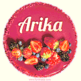 Beautifully decorated red velvet berry birthday cake with vibrant fruits and a glowing 'Arika' name, adding a touch of sweetness and sparkle.