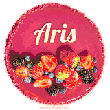 Beautifully decorated red velvet berry birthday cake with vibrant fruits and a glowing 'Aris' name, adding a touch of sweetness and sparkle.
