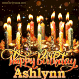 A glowing personalized birthday GIF with name Ashlynn featuring lit candles with intricate designs, warm lighting, and the text 'Happy Birthday' in an elegant font.